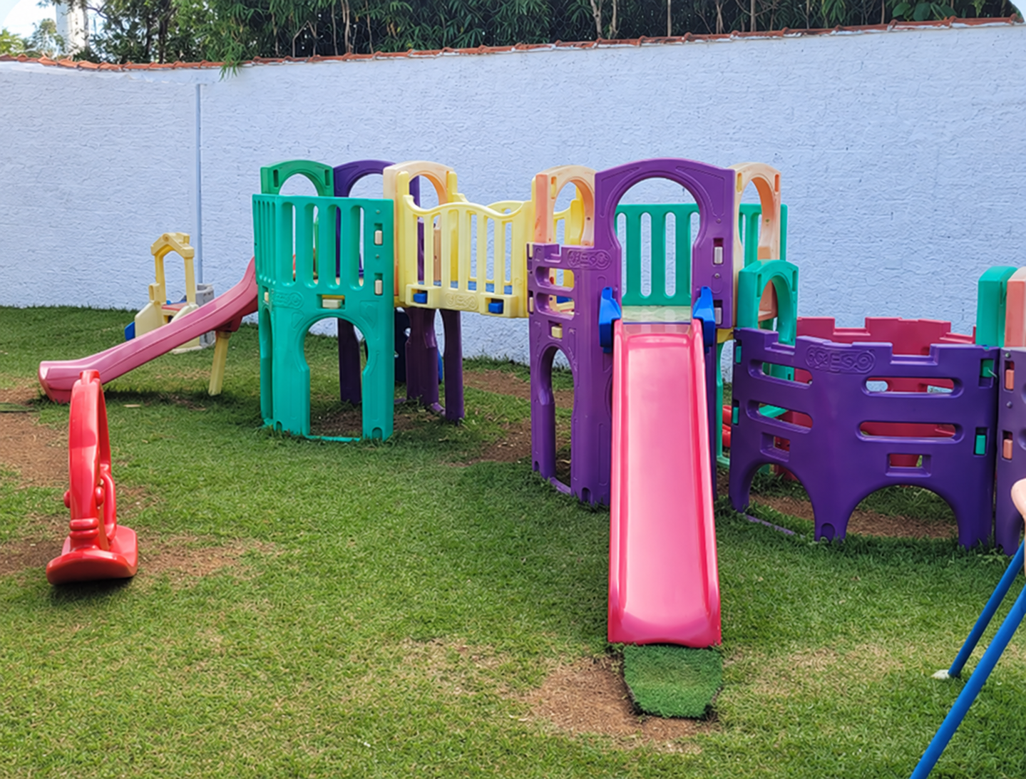 Parque aberto do Espaço Criança Feliz com área verde, gramado e brinquedos